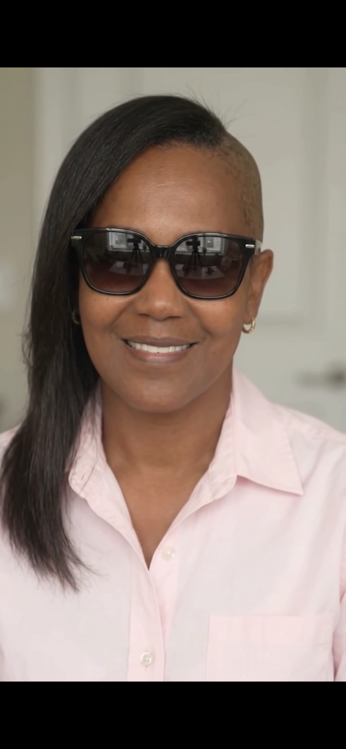 Shantel Y. Johnson, founder of Burned But Blessed LLC, smiling in a pink shirt and sunglasses